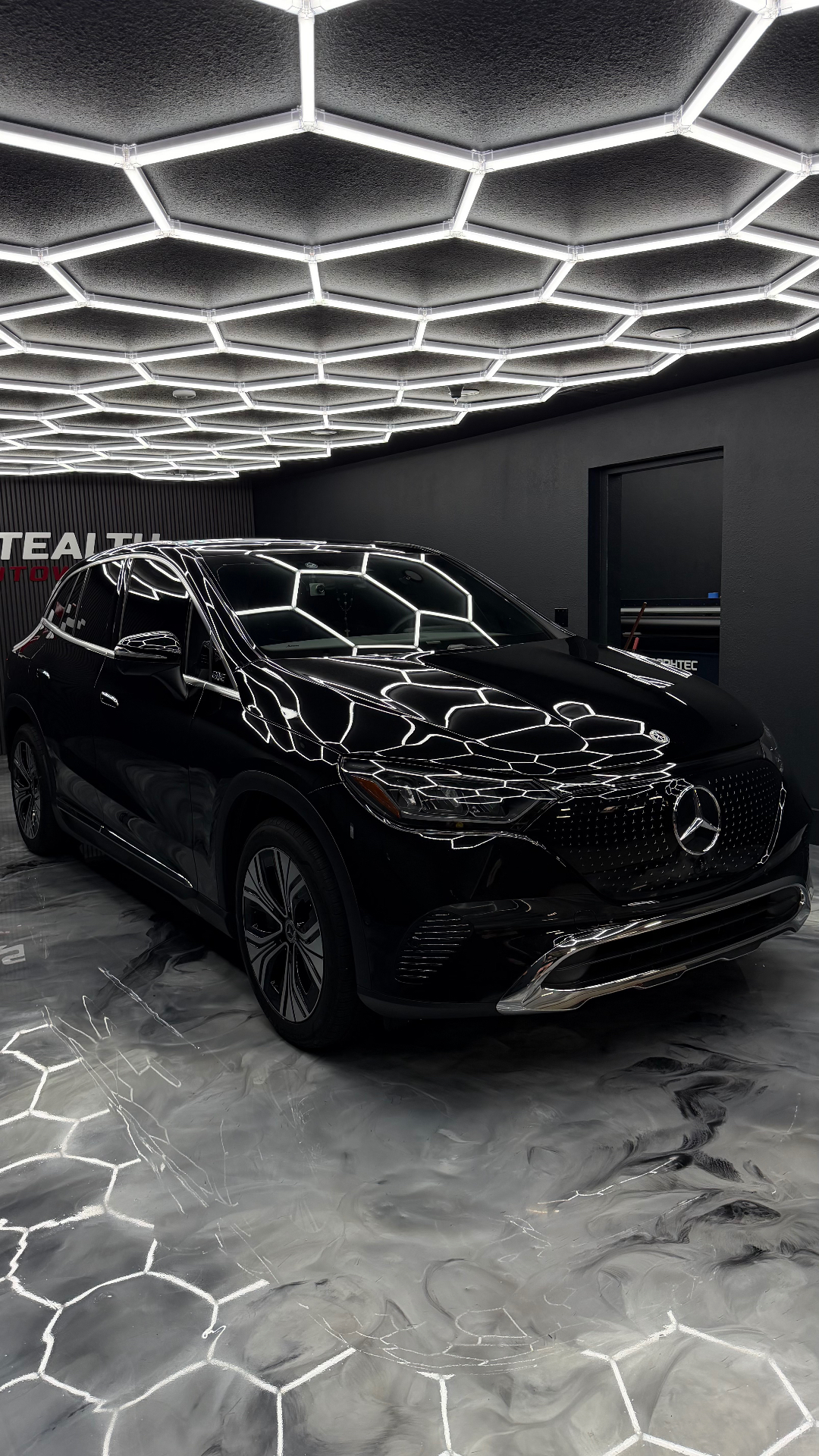 Black Mercedes EQS SUV reflecting hex lighting in the Stealth Autowerks studio